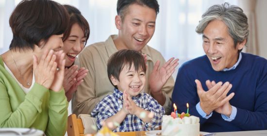 Happy family celebrating a child’s birthday with cake and smiles.