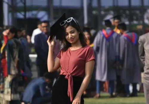 A confident graduate posing with her cap, symbolizing IGEMA’s commitment to empowering students through academic success.