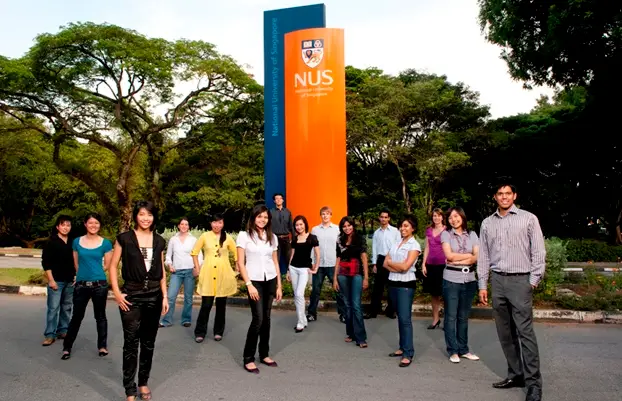 A diverse group of students standing near the National University of Singapore (NUS) sign, symbolizing IGEMA’s collaboration with leading global institutions.